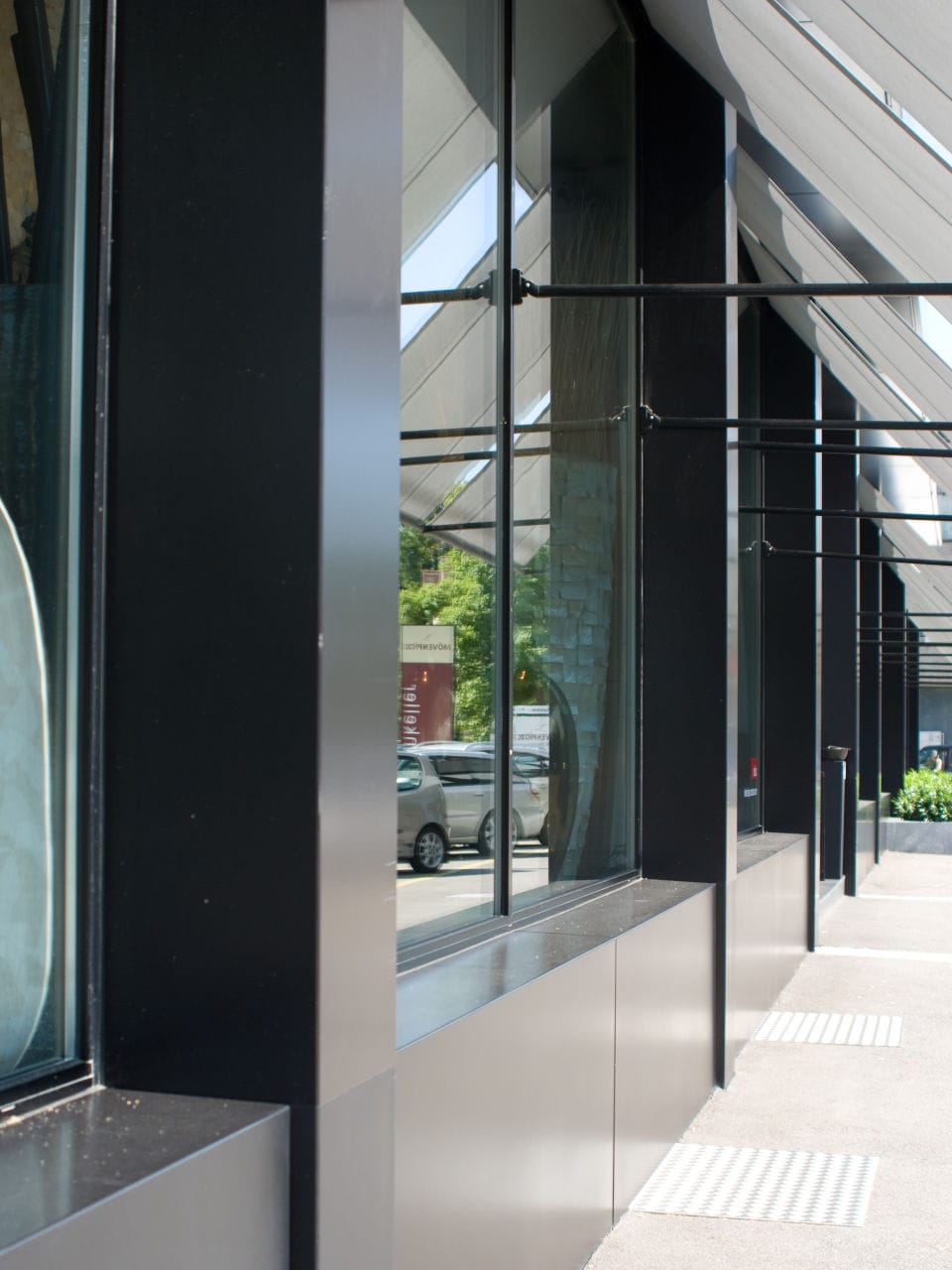 Metallfassade mit Schaufenster mit Sonnenschutz