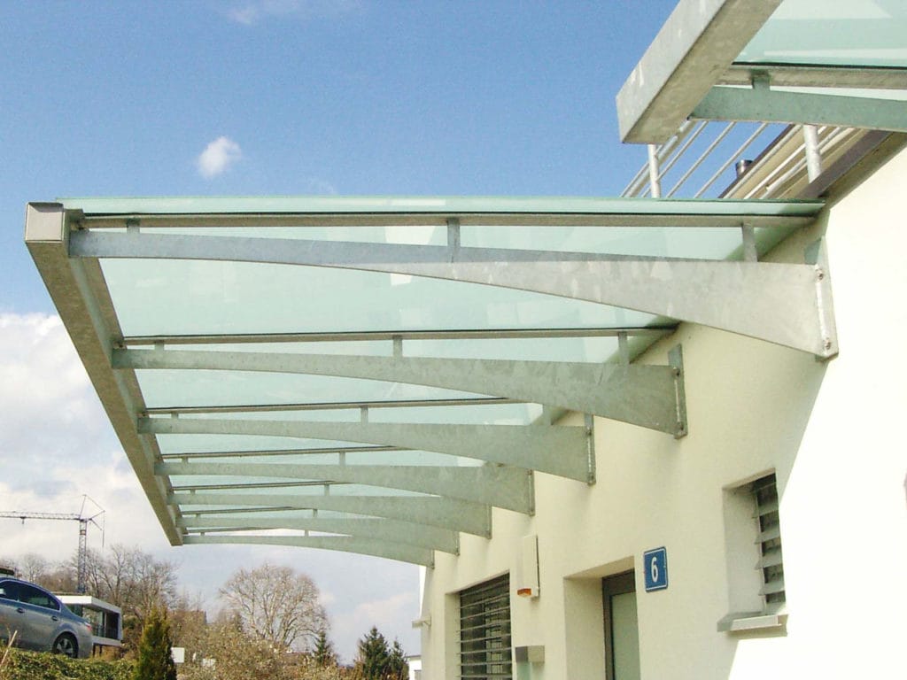 Metallvordach aus Glas und Metall mit rohen Stahlträger